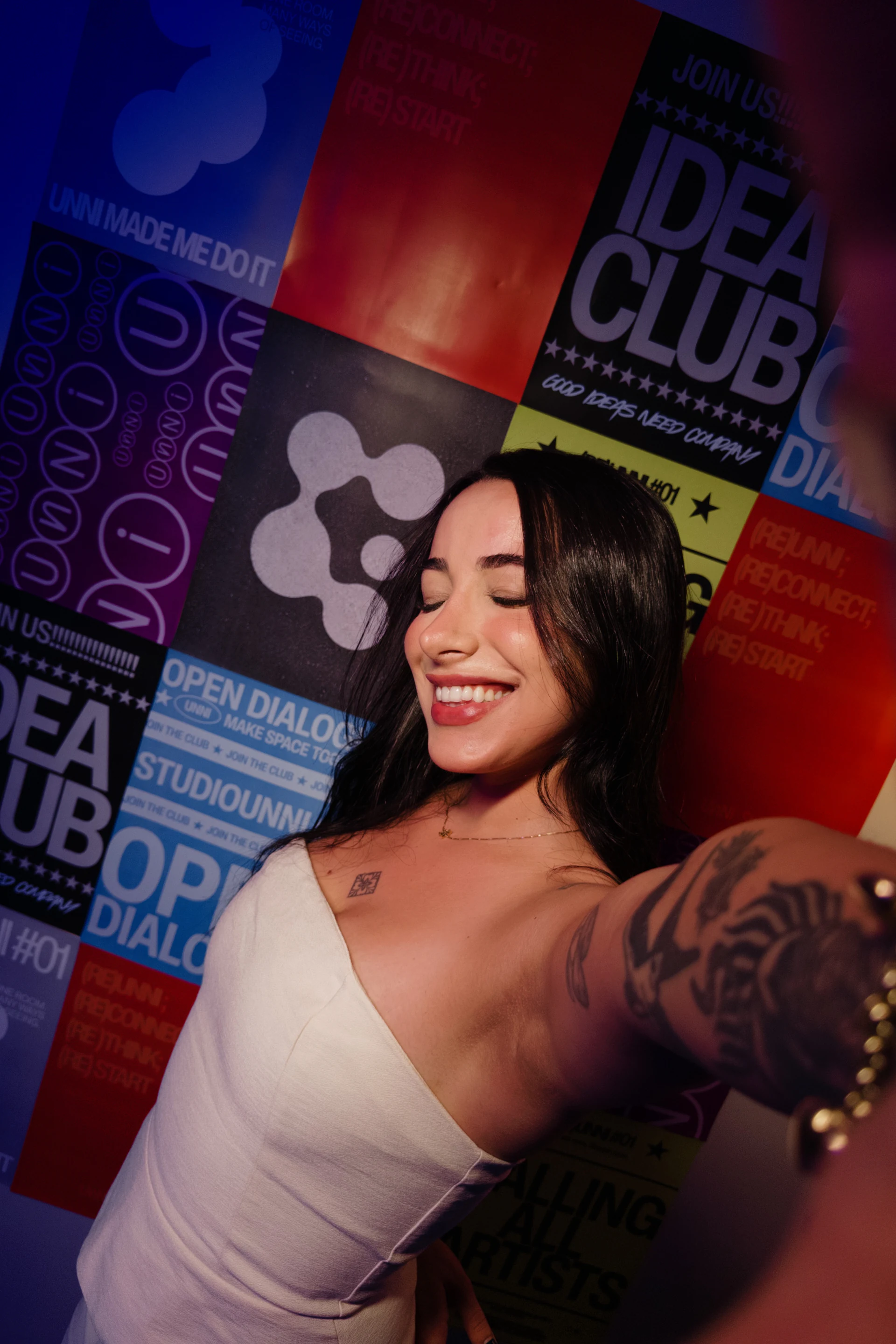 Participante sorrindo em frente ao painel colorido do encontro